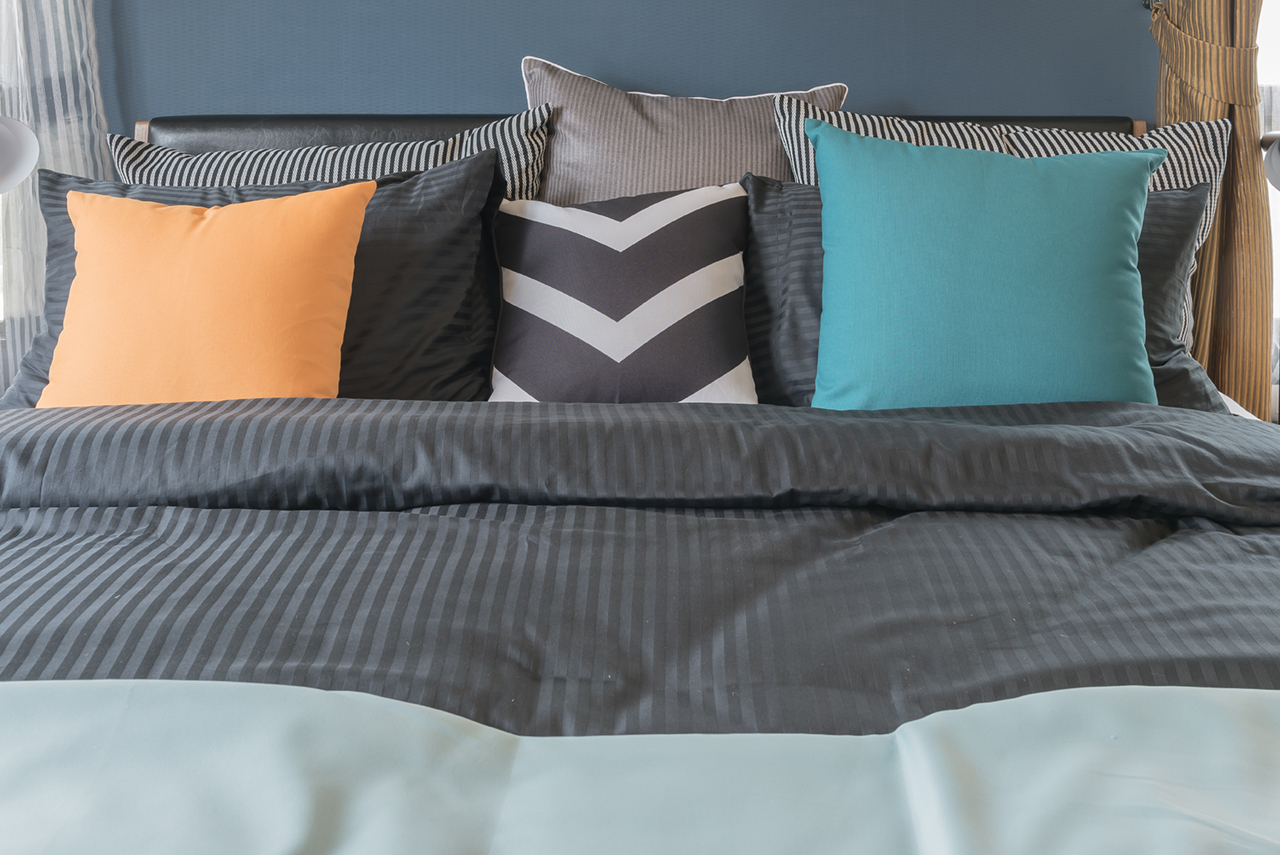 colorful-pillows-on-dark-color-bed-in-modern-bedroom